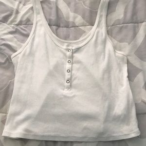 white crop top with buttons in the front.